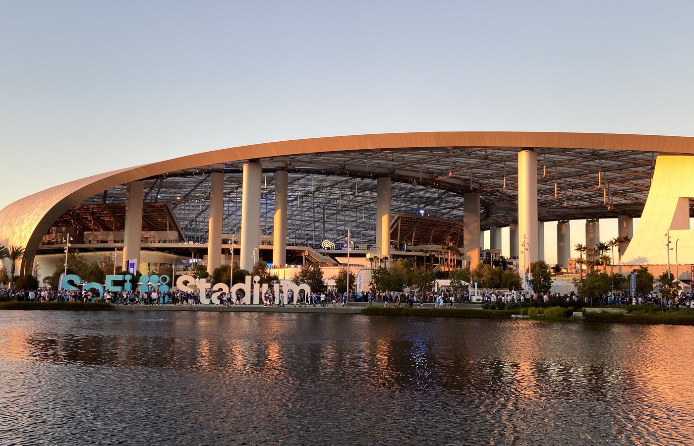 SoFi Stadium exterior at sunset across the lake